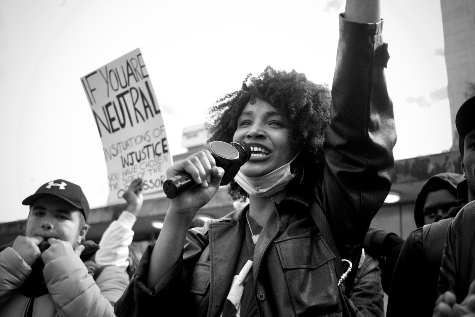 A woman holding up her fist while singing.